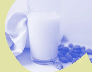 Grafika, na jasnym tle szklanka z mlekiem oraz rozsypane migdały z żółtymi elementami graficznymi. Medicante