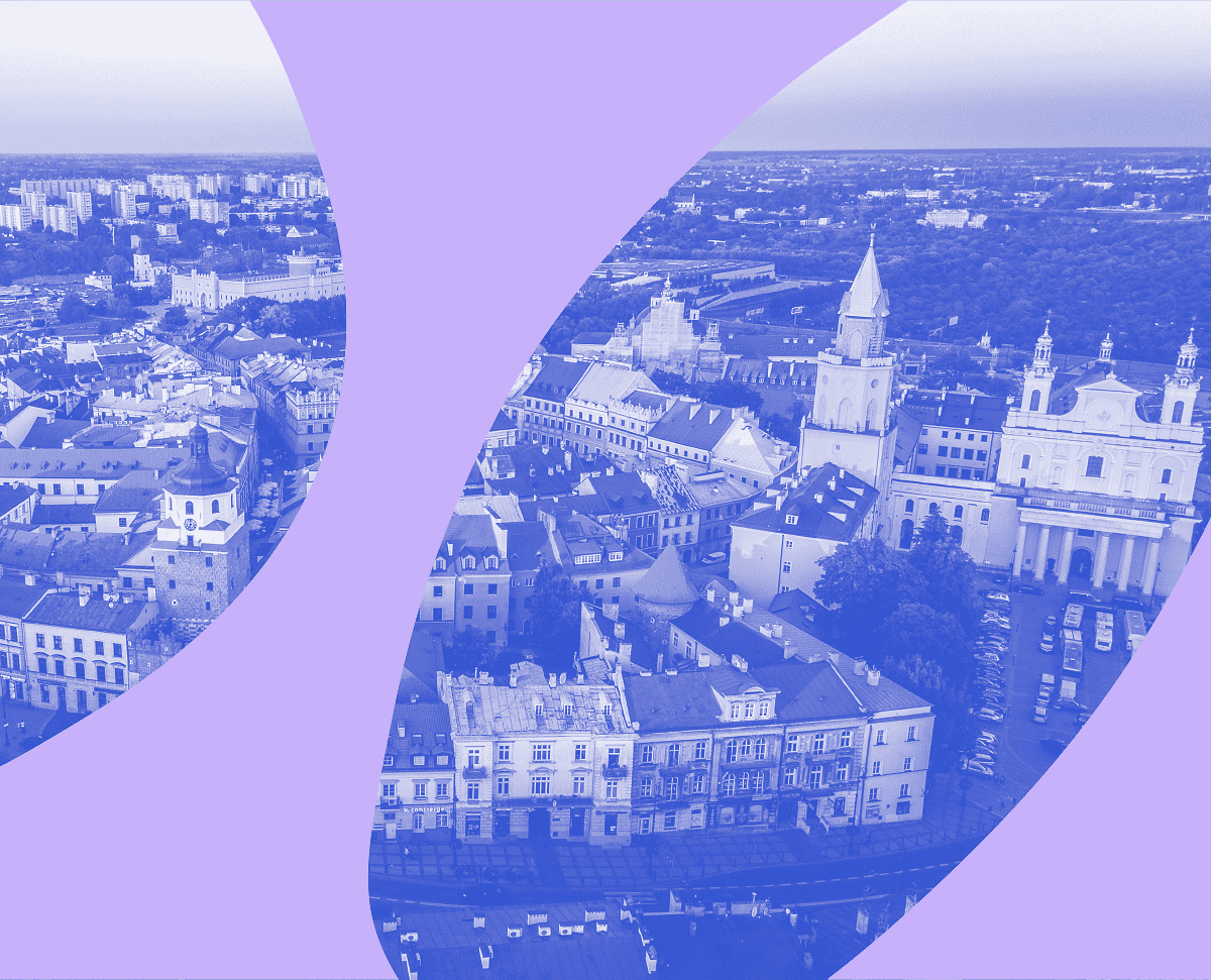 Zdjęcie pięknej panoramy Lublina w monochromatycznym niebieskim kolorze z fioletowym elementem graficznych na przodzie zdjęcia.