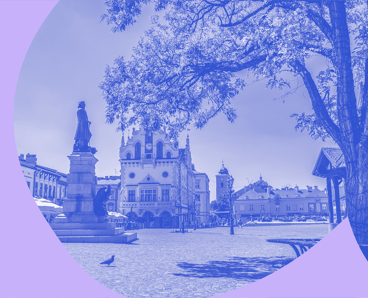 Zdjęcie pięknej starówki w Rzeszowie w monochromatycznym niebieskim kolorze z fioletowym elementem graficznych na przodzie zdjęcia.